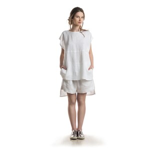 Peut inclure: Une femme portant un haut en lin blanc et un short assorti. Le haut est ample et l&eacute;g&egrave;rement plus long &agrave; l'arri&egrave;re. Le short est large et ample.