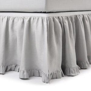 May include: A gray bed skirt with a ruffled edge. The skirt is made of a soft, linen-like fabric.