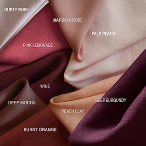 May include: A close-up of fabric swatches in various shades of pink, red, and brown. Colors include Dusty Rose, Marsala Rose, Pink Lemonade, Wine, Pale Peach, Deep Burgundy, Deep Mocha, Peach Clay, and Burnt Orange. The names of the colors are printed on the fabric.