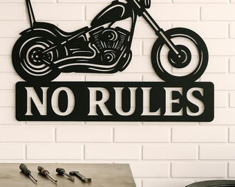 May include: Black metal motorcycle wall art with the text "NO RULES" against a white brick wall. The motorcycle is a detailed silhouette. Tools and tires are visible in the foreground.