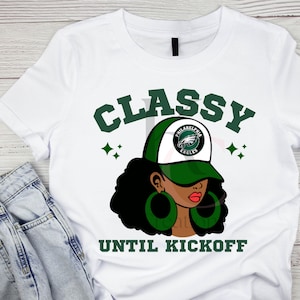 Könnte beinhalten: Weißes T-Shirt mit einer Grafik einer Frau, die eine grün-weiße Philadelphia Eagles-Kappe und grüne Creolen trägt. Das Shirt trägt die grünen Worte "Classy Until Kickoff".