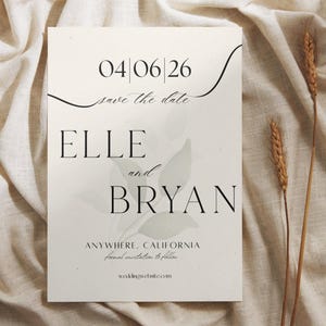 Puede incluir: Una invitación de boda color crema con el texto "04/06/26 save the date ELLE and BRYAN" en negro. La invitación también incluye "ANYWHERE, CALIFORNIA formal invitation to follow" y "weddingwebsite.com". Dos espigas de trigo están a la derecha.