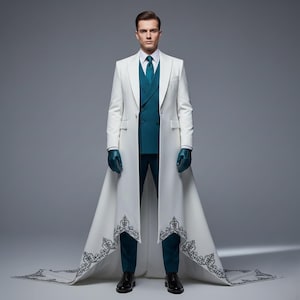 May include: A formal white coat with a long train and intricate black embroidery at the hem. The coat is worn over a teal suit with a matching tie and gloves. Black dress shoes complete the look.