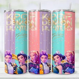 May include: Three stainless steel tumblers with straws, featuring a colorful design. The design includes the text "KPOP DEMON HUNTERS Golden" and illustrations of anime-style characters. The tumblers have a gradient background of purple, teal, and pink.