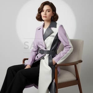 Puede incluir: Un abrigo tipo trench con bloques de color lavanda, blanco y negro. El abrigo tiene cinturón en la cintura, cuello con solapas y un parche con la palabra "ABLURE". La modelo lleva pantalones negros.
