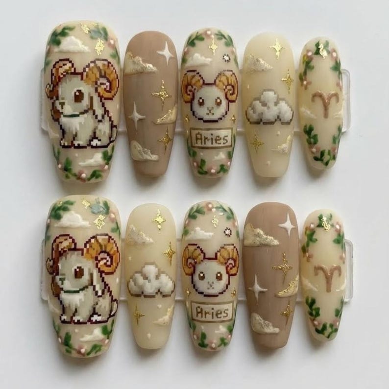 Puede incluir: Un conjunto de diez u&ntilde;as postizas con tem&aacute;tica de Aries. Las u&ntilde;as presentan un carnero pixelado, nubes, estrellas y la palabra "Aries". Los colores incluyen beige, marr&oacute;n y dorado, con detalles florales verdes. Las u&ntilde;as son ovaladas.