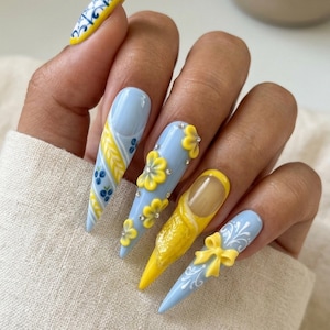 May include: A white ceramic mug with a black handle and the text "But First, Coffee" in a handwritten style. The mug is on a white surface. The mug is approximately 4 inches tall.