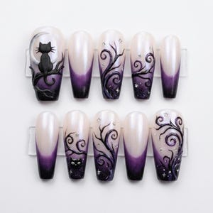 May include: A set of ten press-on nails featuring a pearlescent white to deep purple gradient. Designs include a black cat silhouette on a crescent moon, swirling dark branches, and small silver star accents across the various nail surfaces.