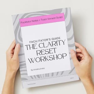 May include: A book titled "FACILITATOR'S GUIDE THE CLARITY RESET WORKSHOP" is held by two hands. The book has a white cover with black text and a pink header that reads "Facilitator Notes + Team Version Script". The background is a light gray and white.