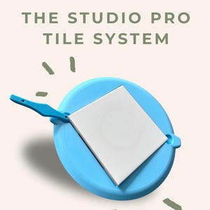 May include: A light blue tile system holding a white tile. The text "THE STUDIO PRO TILE SYSTEM" is at the top. The Pearl & Fern Co logo is at the bottom.