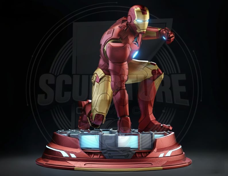 May include: A red and gold Iron Man statue in a dynamic pose, kneeling on a platform with blue lighting. The statue is detailed with metallic textures and is set against a dark background. The word "SCULPTURE" is visible in the background.