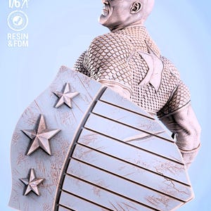 May include: A detailed statue of a superhero figure, holding a shield with star emblems. The figure is clad in a textured, scale-like armor. The shield has a wooden plank design. The statue is labeled "SCALE 1/6" and "RESIN & FDM".