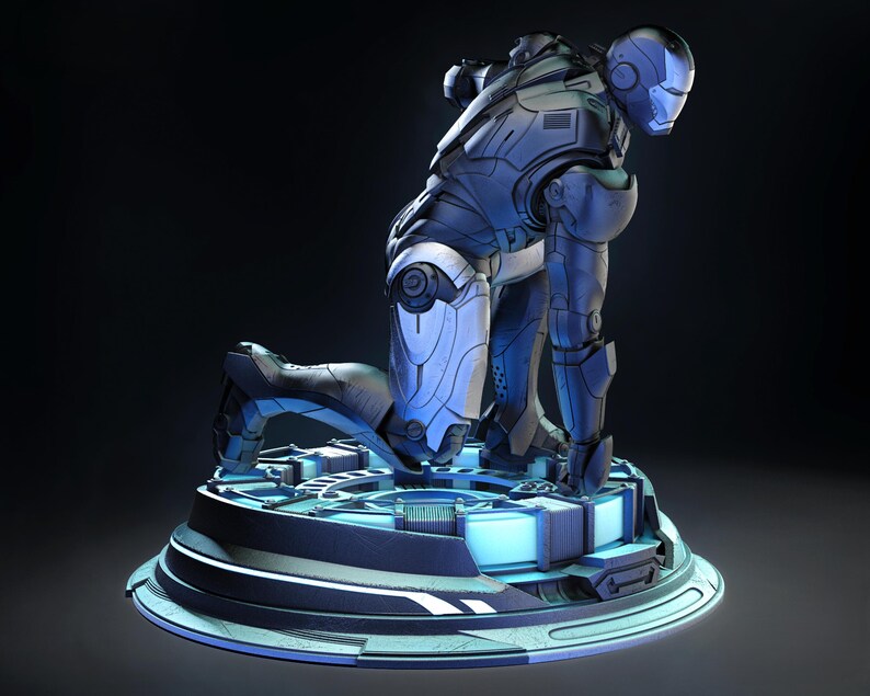 May include: A detailed, blue and silver Iron Man action figure in a kneeling pose. The figure is on a circular, futuristic-looking base with glowing blue accents. The armor has intricate paneling and a helmet with a distinctive faceplate.