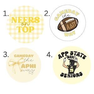 May include: Four round stickers with yellow and white designs. One says "NEERS on TOP" in yellow. Another has a football and says "GAMEDAY the WAY". A third has a bow and says "GAMEDAY the APHI way". The last says "APP STATE ADPI SENIORS".