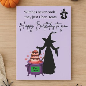 May include: A lavender birthday card with a witch theme. The card features a witch silhouette, a cauldron with a cake, and the text "Witches never cook... they just Uber Heats. Happy Birthday to you."