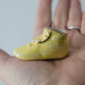 Vintage miniature yellow ceramic shoe or bootie with gold trim