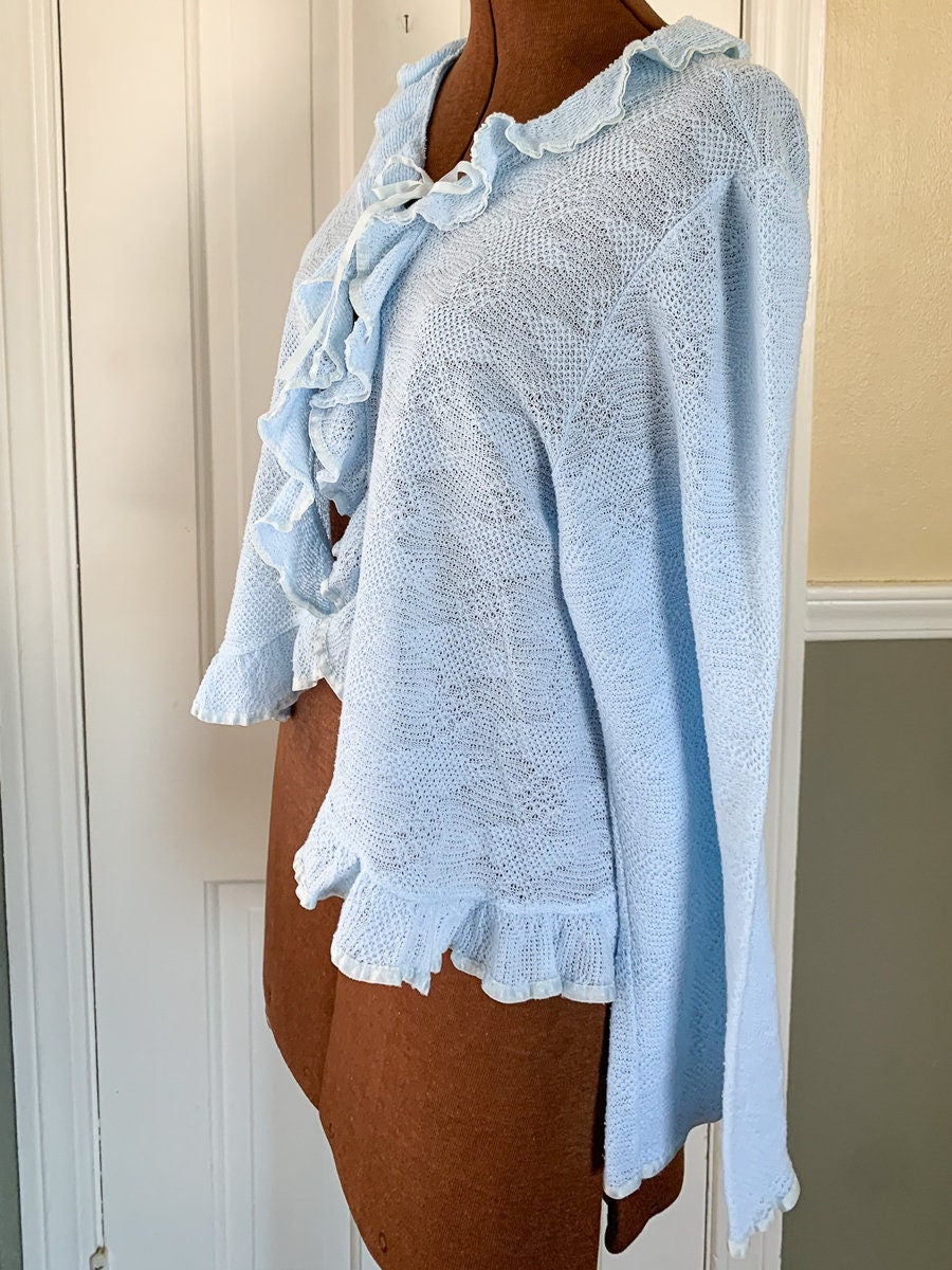Vintage 1960s knit light blue bed jacket with ruffle and ribbon trim