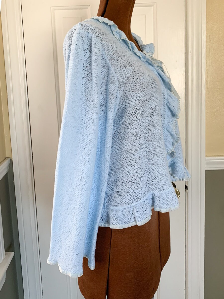 Vintage 1960s knit light blue bed jacket with ruffle and ribbon trim