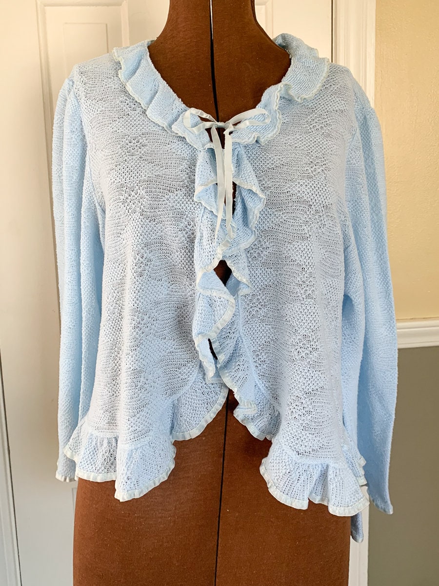 Vintage 1960s knit light blue bed jacket with ruffle and ribbon trim