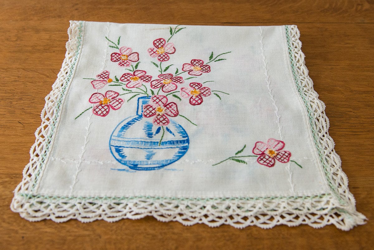 Vintage embroidered dresser scarf or table runner with vase of dogwoods