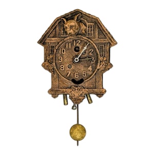 May include: A brown cuckoo clock with a decorative house-shaped design. The clock features a round face with black numerals and hands, a pendulum, and a small dog-like figure at the top. The clock is made of a dark brown material.