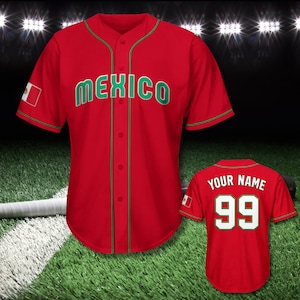 May include: Red baseball jersey with "MEXICO" in green lettering. The jersey has green trim and a small Mexican flag on the sleeve. A second jersey shows "YOUR NAME" and the number 99 on the back.