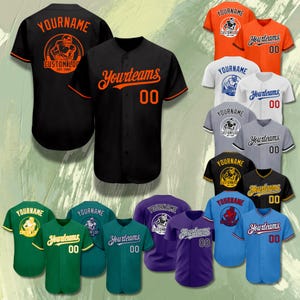 Könnte beinhalten: Auswahl an Baseball-Trikots in verschiedenen Farben, darunter Schwarz, Orange, Grün und Blau. Jedes Trikot zeigt individuellen Text, Teamnamen und Nummern. Einige Trikots haben ein rundes Logo auf dem Rücken.