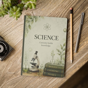 Könnte beinhalten: Ein Notizbuch mit hellgrünem Einband, einem Atomsymbol, dem Text "SCIENCE" und "Curiosity builds knowledge", einem Mikroskop, Glasbechern mit Pflanzen sowie einem Stapel Bücher mit der Aufschrift "BIOLOGY", "CHEMISTRY" und "PHYSICS".