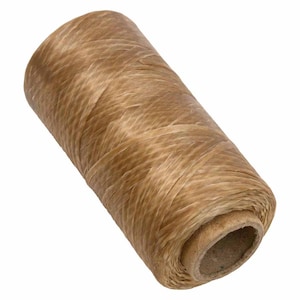 May include: A spool of natural-colored twine, ideal for crafting and packaging. The twine is tightly wound around a cardboard core, showcasing a textured surface. The color is a warm, earthy tone.
