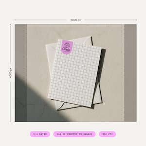 May include: A white notepad with a grid pattern and a purple sticker that says "Clearly" rests on top of a white envelope. The notepad is angled, and the background is a neutral beige color.