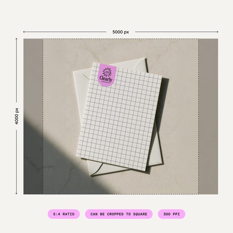May include: A white notepad with a grid pattern and a purple sticker that says "Clearly" rests on top of a white envelope. The notepad is angled, and the background is a neutral beige color.