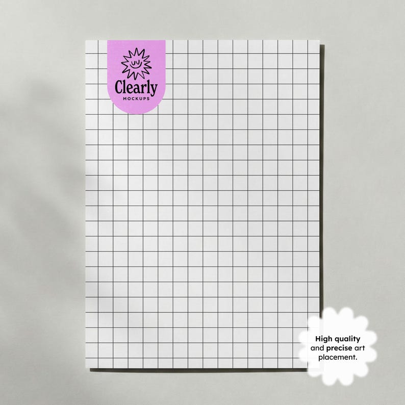 May include: A white sheet of grid paper with black lines, featuring a purple sticker with the text "Clearly Mockups" and a sun illustration. A white flower-shaped graphic with the text "High quality and precise art placement" is in the bottom right corner.