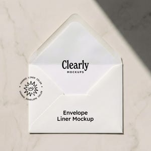 Puede incluir: Un sobre blanco abierto, que revela un forro blanco, con el texto negro "Clearly MOCKUPS". Las palabras "Envelope Liner Mockup" están debajo. Un pequeño gráfico circular con texto está en la esquina inferior izquierda.