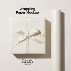 May include: A wrapped gift box with a satin ribbon bow and a roll of wrapping paper. The gift box and paper are off-white. The text "Wrapping Paper Mockup" is at the top, and "Clearly Mockups" is at the bottom.