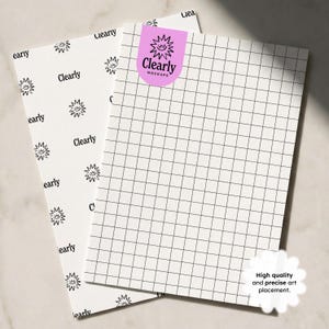 Op de afbeelding: Twee witte vellen papier met raster- en patroonontwerpen. E&eacute;n vel heeft een rasterpatroon, de andere heeft een herhalend zonachtig ontwerp en het woord "early". Een roze sticker met de tekst "Clearly Mockups" staat op het rastervel. Een witte sticker zegt "High quality and precise art placement."