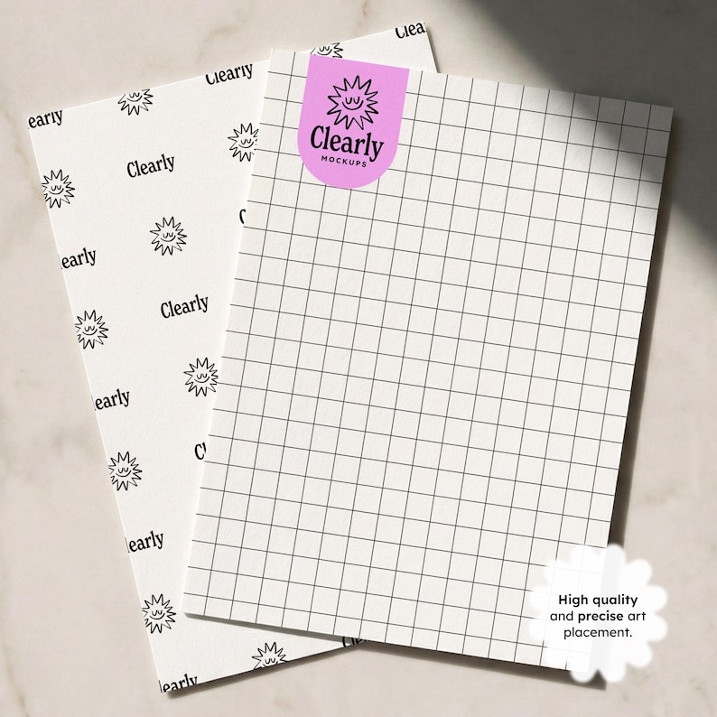 Op de afbeelding: Twee witte vellen papier met raster- en patroonontwerpen. E&eacute;n vel heeft een rasterpatroon, de andere heeft een herhalend zonachtig ontwerp en het woord "early". Een roze sticker met de tekst "Clearly Mockups" staat op het rastervel. Een witte sticker zegt "High quality and precise art placement."