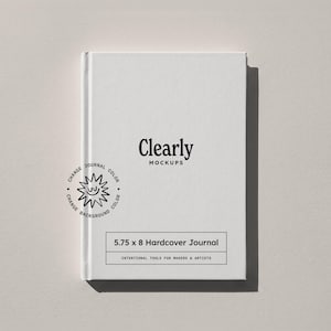 May include: A white hardcover journal with the text Clearly Mockups printed in black. A circular graphic with a smiling sun icon and the text Change Journal Color and Change Background Color is visible. A label reads 5.75 x 8 Hardcover Journal.