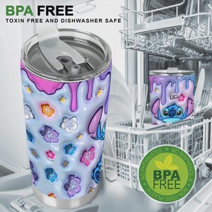 Pode incluir: Um copo de a&ccedil;o inoxid&aacute;vel com um design colorido com um personagem de desenho animado e detalhes florais. O copo tem uma tampa e &eacute; decorado com um efeito de tinta escorrendo em rosa e roxo. O texto "BPA FREE" &eacute; vis&iacute;vel.