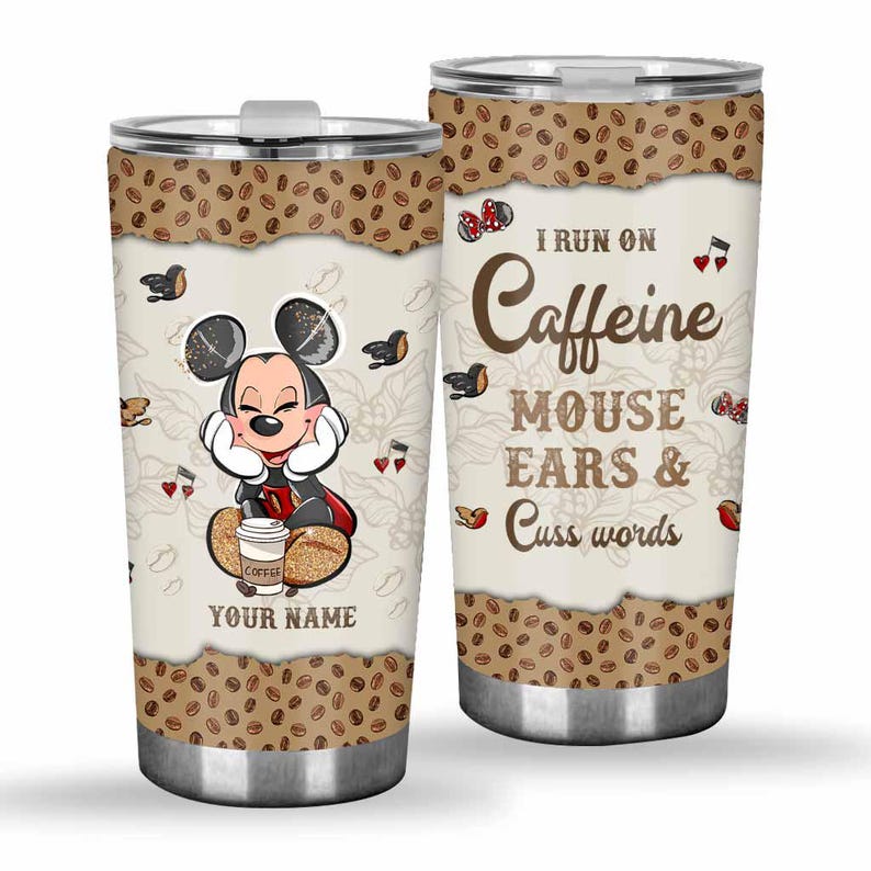 May include: A stainless steel tumbler featuring a cartoon Mickey Mouse design. The tumbler has a coffee bean border and the text "I run on Caffeine Mouse Ears & Cuss Words". The design includes musical notes and coffee cups.