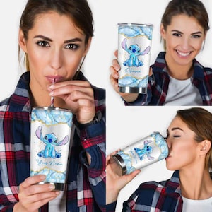 May include: A stainless steel tumbler featuring a blue cartoon character design. The tumbler has a white background with blue and gold accents. The text "Your Name" is printed on the tumbler.