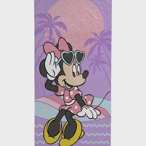 May include: A beach towel featuring Minnie Mouse in a pink polka-dot dress and heart-shaped sunglasses. The background includes a sunset, palm trees, and a wavy design in shades of purple, pink, and blue. The towel is rectangular.