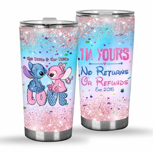 Pu&ograve; includere: Un paio di bicchieri in acciaio inossidabile con un design glitterato. Uno presenta personaggi blu e rosa con la parola "LOVE". L'altro dice "I'M YOURS No Returns Or Refunds Est 2015".
