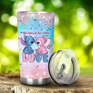Pu&ograve; includere: Un bicchiere in acciaio inossidabile con un design colorato con due personaggi dei cartoni animati, uno blu e uno rosa, con la parola "LOVE" al centro. Il bicchiere ha un coperchio trasparente e il testo "His Name & Her Name".