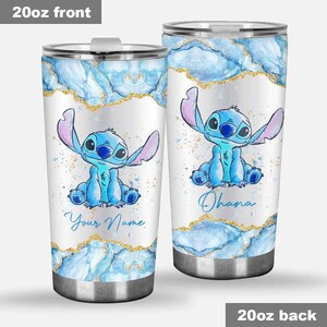 May include: Two 20oz stainless steel tumblers. Each tumbler features a blue cartoon character with large ears, set against a white background with blue and gold accents. One tumbler says "Your Name" and the other says "Ohana".