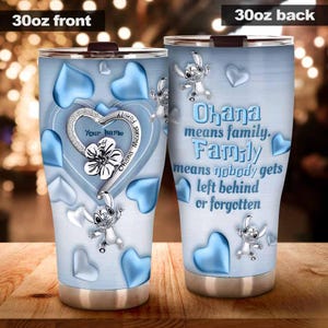 May include: A 30oz stainless steel tumbler with a light blue background and a heart design. The front features a heart-shaped charm with the text "Your Name" and "Ohana Means Family." The back reads "Ohana means family. Family means nobody gets left behind or forgotten."