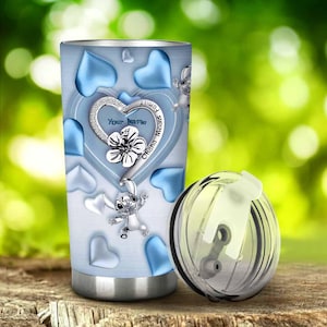 May include: A stainless steel tumbler with a lid, featuring a design with blue hearts and a heart-shaped pendant with the text "Your Name" and "Ohana Means Family". A cartoon character is also featured.