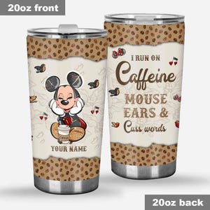 May include: A 20oz stainless steel tumbler with a lid. The front features a cartoon mouse character with the text "YOUR NAME" and "COFFEE". The back says "I RUN ON Caffeine MOUSE EARS & Cuss words". The top and bottom have a coffee bean design.
