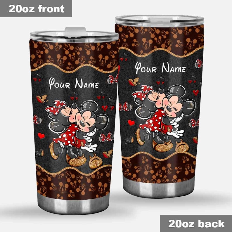 Puede incluir: Dos vasos de acero inoxidable de 20 oz con un dise&ntilde;o de Mickey y Minnie Mouse abraz&aacute;ndose. Los vasos tienen un fondo negro con un borde dorado, corazones rojos y mariposas. El texto "Your Name" est&aacute; impreso en la parte delantera.