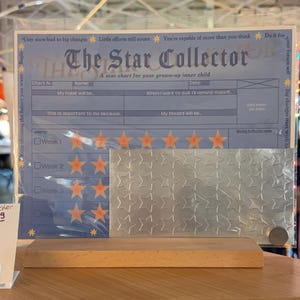 May include: A star chart titled "The Star Collector" with space for goals and rewards. Includes a sheet of silver star stickers and a wooden base. The chart has prompts for habits and weekly reflections.