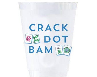 May include: A translucent white plastic cup featuring the blue text CRACK DOT BAM printed on the front. The design includes small illustrations of Mahjong tiles with green, red, and blue symbols interspersed among the words on the cup surface.